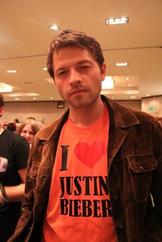 a man wearing an orange shirt and jacket