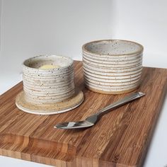 a wooden cutting board topped with lots of white dishes