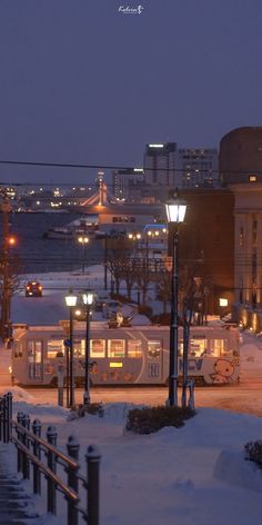 a bus is parked on the side of the road covered in snow at night time