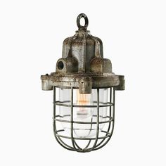 an old light hanging from the ceiling with caged wire around it and a bulb on top