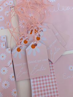 pink and white tags with daisies on them are displayed next to eachother