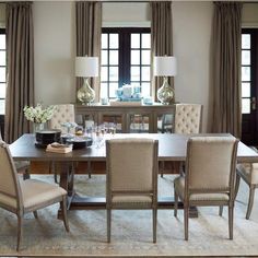 a dining room table with beige chairs around it