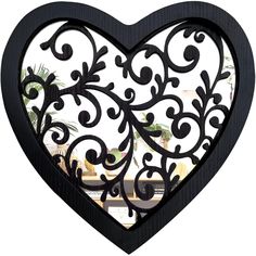 a black heart shaped mirror hanging on the wall