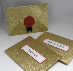 two gold glittered cards with red and black ribbon on them, one is for best dressed