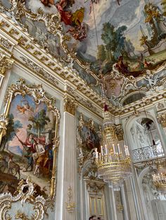 an ornate ceiling with paintings and chandeliers in a room filled with white walls