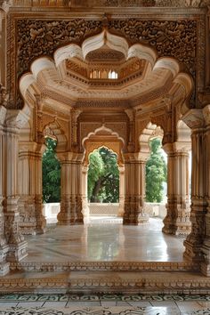 the inside of an ornate building with columns and arches on either side, surrounded by trees