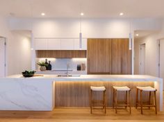 a kitchen with marble counter tops and stools