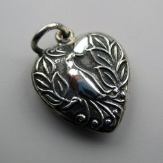 "This antiqued sterling silver, two-sided, repousse Puffy heart Charm number 26 features a peacock immersed in dense foliage. Marked, Sterling. Made by Brown County Silver. Vintage and in new, never worn condition. Approximately 30 years old. 3/4\" high with jump ring 1/2\" wide 1.4 grams approx. *Chain sold separately See more @ https://www.etsy.com/shop/brocosi" Valentine's Day Antique Silver Heart Charm Jewelry, Vintage Metal Heart Charms, Vintage Metal Heart Charm, Antique Heart-shaped Jewelry With Vintage Charm, Ornate Heart-shaped Vintage Charm Jewelry, Brown County, Puffy Heart Charms, Sterling Silver Charm Bracelet, Jewelry Personalized