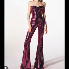 a woman in a purple sequin jumpsuit posing for the camera with her hand on her hip