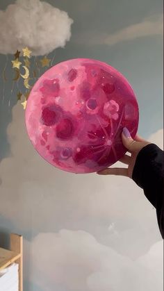 a person holding a pink frisbee in front of a sky with gold stars