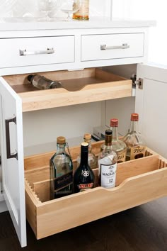 an open drawer with liquor bottles in it