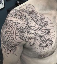 a man's chest with a dragon tattoo on his chest and chest, in black ink