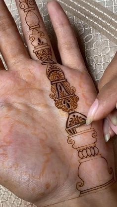 a woman's hand with henna tattoos on it