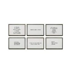 four white and black framed pictures with different words on the front, one is in an empty