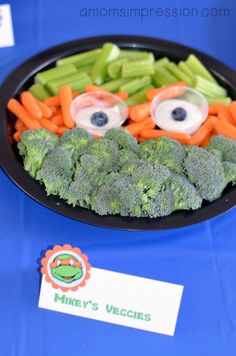 a plate with broccoli, carrots and eyeballs in the shape of eyes