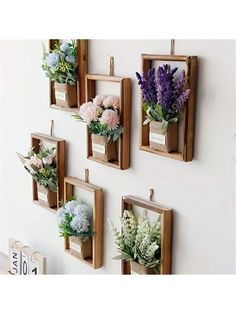 four wooden frames with flowers hanging on the wall