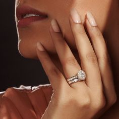 a close up of a woman's hand with a diamond ring on her finger