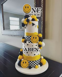 a three tiered cake with smiley faces on it