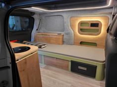 the interior of an rv with wood flooring and storage compartments on each side of the vehicle