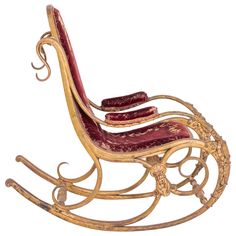 a wooden rocking chair with red velvet cushions