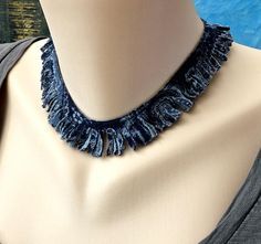 a mannequin wearing a blue necklace with fringes on it's neck