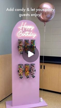 a candy machine with balloons and confetti on it