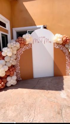 an arch made out of balloons with the word mr and mrs on it