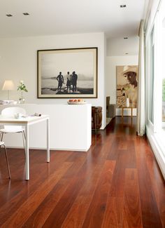 a living room filled with furniture and a painting on the wall next to a window