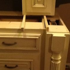 an old fashioned white dresser with drawers and knobs