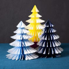 three origami christmas trees sitting next to each other on top of a table