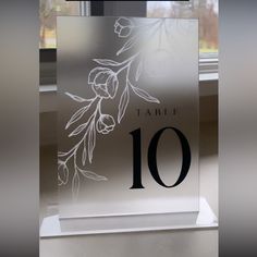 a glass table number sitting on top of a window sill