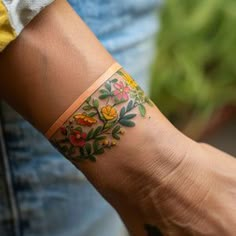 a woman's arm with a flower tattoo on the left side of her arm