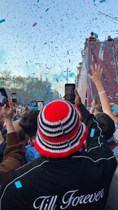 people are taking pictures with their cell phones and confetti is being thrown in the air