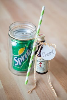 a glass jar with a green and white striped straw next to a bottle of spritet