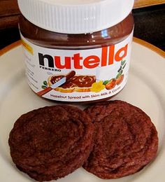 there is a jar of nutella and two cookies on the plate