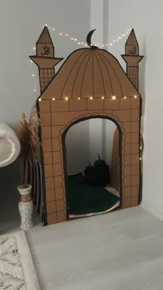 a cat house made out of cardboard with lights on the top and bottom part of it