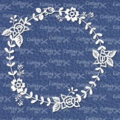 a white paper wreath with flowers and leaves on blue leather background, cut out in the shape of a circle