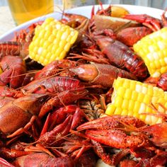 crawfish, corn on the cob and beer are served in a bowl