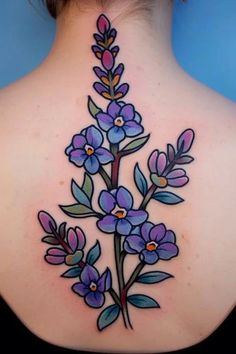 the back of a woman's neck with purple flowers on her left and blue leaves on