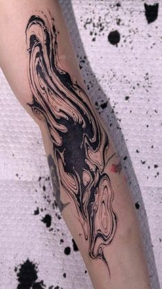 a woman's arm with black ink on it and an abstract design in the middle