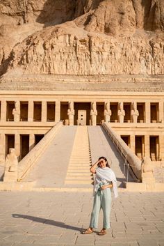 a woman standing in front of an ancient building