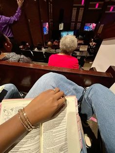 a woman is reading a book while others watch