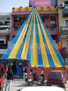 a large blue and yellow tent sitting on the side of a road next to a building