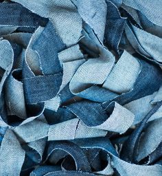 blue jeans are piled up together in this close - up photo, which shows the fabric's very thinness