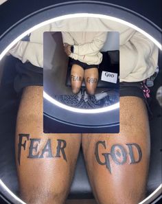 two people with tattoos on their legs sitting in front of a mirror that says, fear god