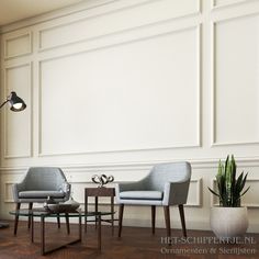 a living room with two chairs, a table and a lamp on the side wall