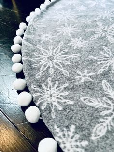 a round rug with white pom poms on it