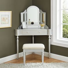 a white vanity with a mirror and stool