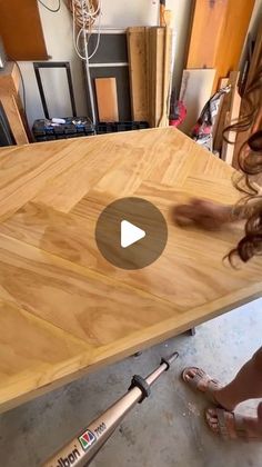 a woman is sanding up a wooden table