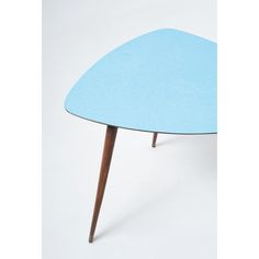 a blue table with wooden legs and a triangular shaped design on the top, against a white background